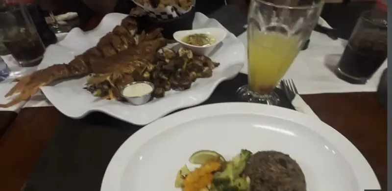 Cooked fish and seafood plates at Caramba in Triana’s Belize vlog